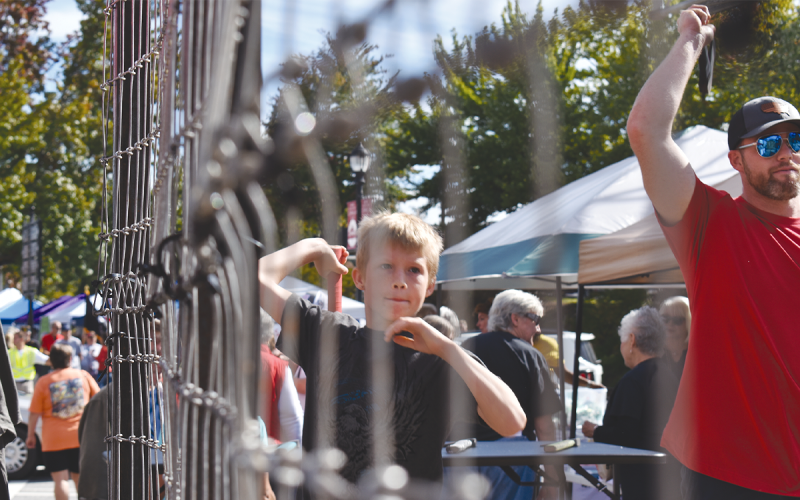 Dallas Rogers fires an axe at last year’s Big Red Apple Festival. FILE