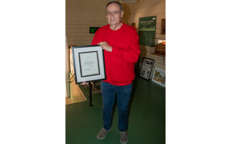 Buck Snyder, president of the Cornelia Depot Association, holds a thank-you letter sent from the White House and President George H.W. Bush after Bush’s 1992 visit to Cornelia. KIMBERLY BROWN/Staff