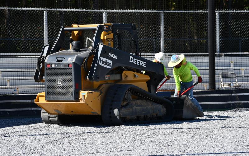 Workers from Hellas Sports Construction get the field ready for the laying of artificial turf at Raider Park in Demorest. MATTHEW OSBORNE/Staff
