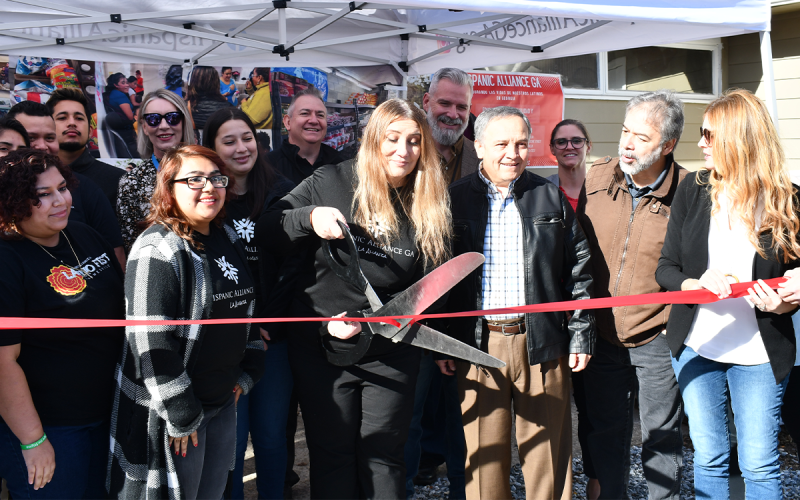Vanesa Sarazúa cuts the ribbon to open the Habersham branch of Hispanic Alliance Georgia. JOHN DILLS/Staff