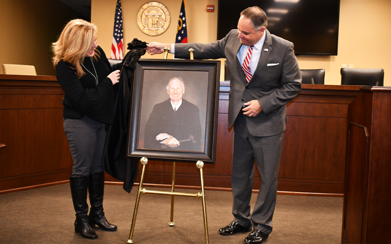 Boen Butterworth Nutting and James Butterworth unveil a portrait of their father, Judge Jim Butterworth, at the Habersham County Courthouse Friday afternoon. The portrait will hang in the magistrate courtroom. MATTHEW OSBORNE/Staff