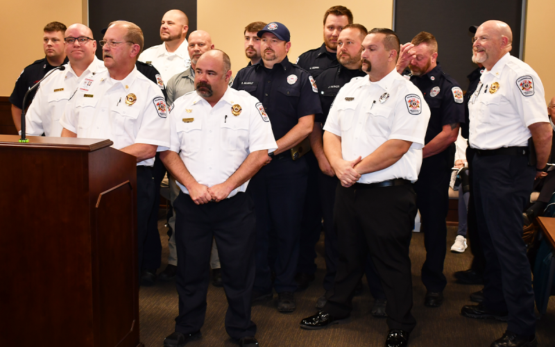 Habersham County Emergency Service employees (from left) Jeff Brown, Jason Davey, Chief Jeff Adams, Jason Garrett, Brad Davidson, Ronnie Davis, Bryan Nix, Randi Seabolt, Mark Gerrin, Jeff Parker, Mack Palmer, Jamie Tyler, Royce Eller and Bill Ramsey stand up in solidarity at Thursday’s special called meeting of the Habersham County Board of Commissioners. MATTHEW OSBORNE/Staff