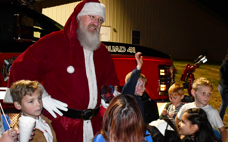 Children in Baldwin rush to greet Santa Claus after he was brought to the celebration by the Baldwin Fire Department. MATTHEW OSBORNE/Staff