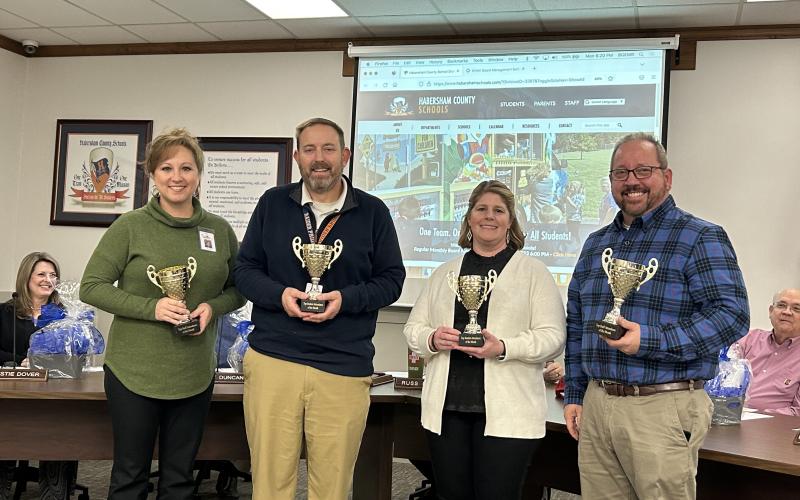Principals (from left) Lana Jones, Jonathan Stribling, Georgia Pitts and Ernie Garrett receive their attendance trophies at Monday night’s Board of Education meeting. EMMA MARTI/Staff