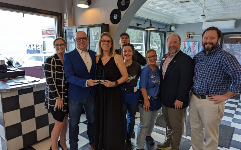 Accepting Fenders Alley’s travelblazer award on Wednesday are (from left) Jessie Owensby, Cornelia’s Community  Development Director; Fenders owners Jay and Melissa Reeder; employees Nelson Arias (in back), Mady Maysonet and  Kris Bernadino; Jay Markwalter, president of Georgia Convention and Visitors Bureau; and Cornelia Mayor John Borrow. STEFANIE BOWDEN/Staff