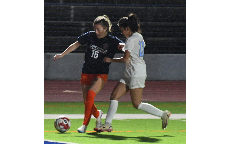 Habersham Central’s Paisley Cathey looks to power through a  Johnson defender and the rain on the way to the goal Tuesday night. MATTHEW OSBORNE/Staff