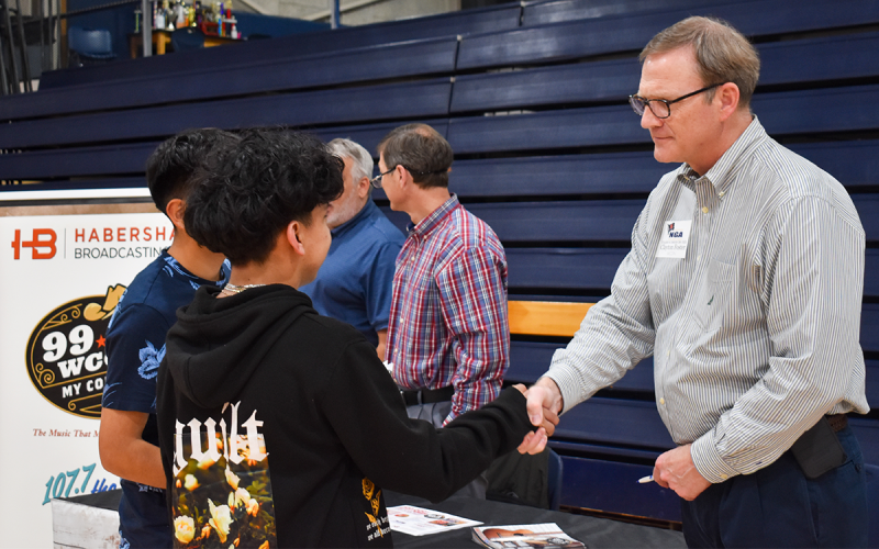 Vice President of Habersham Broadcasting Company Clayton Foster shakes hands with a student before they discuss what Foster does in his position. Students at the College and Career Day were met with a variety of colleges and companies in nearby areas to discover opportunities for post high school life. EMMA MARTI/Staff
