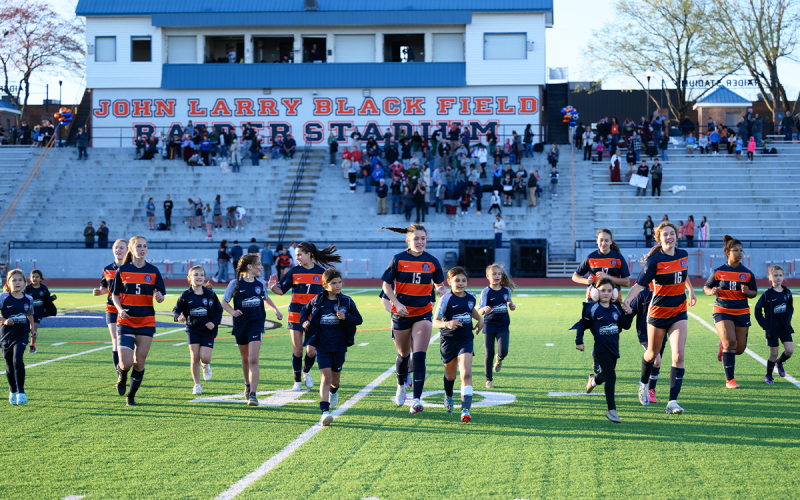 The Lady Raiders jog off the field alongside the Habersham FC Rapids players after the national anthem on Friday night. ZACH TAYLOR/Special