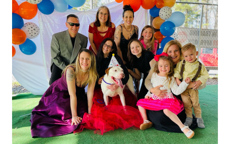 Habersham County Animal Care and Control staff and volunteers gather around to celebrate Mutley (center), and all of his growth since being at the shelter. From left, Director of HCACC Madi Nix, Floyd Jones, Jennifer Newcomb, Lillie Applegarth, Olivia Whitfield, India Kelley, Brittany Brown and her children. SUBMITTED