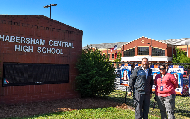 HCHS Principal Dr. Jonathan Stribling (left) and Dual Enrollment/College Coordinator Dora Lucas (right) stand in front of some of the senior banners. EMMA MARTI/Staff
