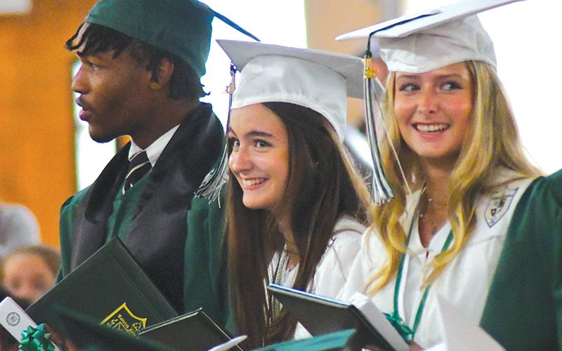 With fellow graduate Frankey Moree, Tallulah Falls seniors Meredith Morris and Madeline Mullis share a laugh during the May 19 ceremony. ENOCH AUTRY/CNI News Service