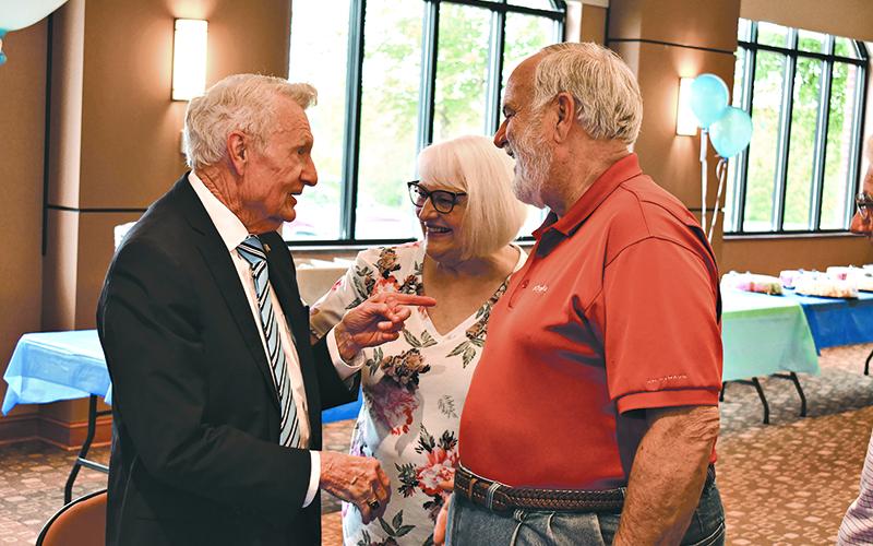 Larry Whitfield talks with Rick and Joan Williams during his birthday party May 19.