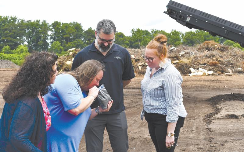 Baldwin Councilwoman Stephanie Almagno, Mayor Alice Venter, ReveSolutions Owner Carlos Talbott and Baldwin Chief Administrative Officer Emily Woodmaster take a moment to smell the compost end-product from the Athens-Clarke County Solid Waste Department. JOHN DILLS/Staff