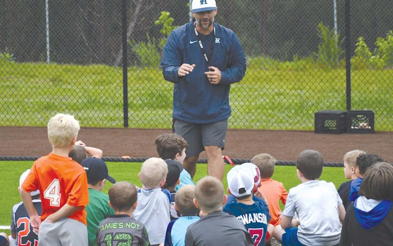 Raiders varsity coach Chris Akridge addresses the campers who braved the rain Thursday. LANG STOREY/Staff