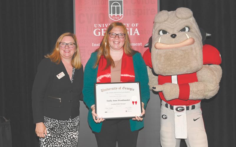 Emily Woodmaster (center) is recognized as a Certified Public Manager by the University of Georgia’s Carl Vinson Institute of Government. Woodmaster is the Chief Administrative Officer and City Clerk for the City of Baldwin. Pictured left to right are Marci Campbell and Hairy Dawg.