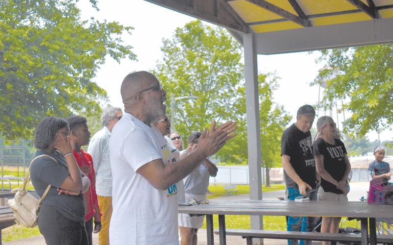 Shady Grove Missionary Baptist Church Pastor Ernest Burns sings along to the Black National Anthem during Saturday’s festivities. EMMA MARTI/Staff