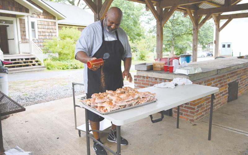 Glen Dorsey seasons approximately 60 pounds of chicken legs and thighs for the Juneteenth potluck dinner at Sautee Nacoochee Cultural Center. ZACH TAYLOR/Special