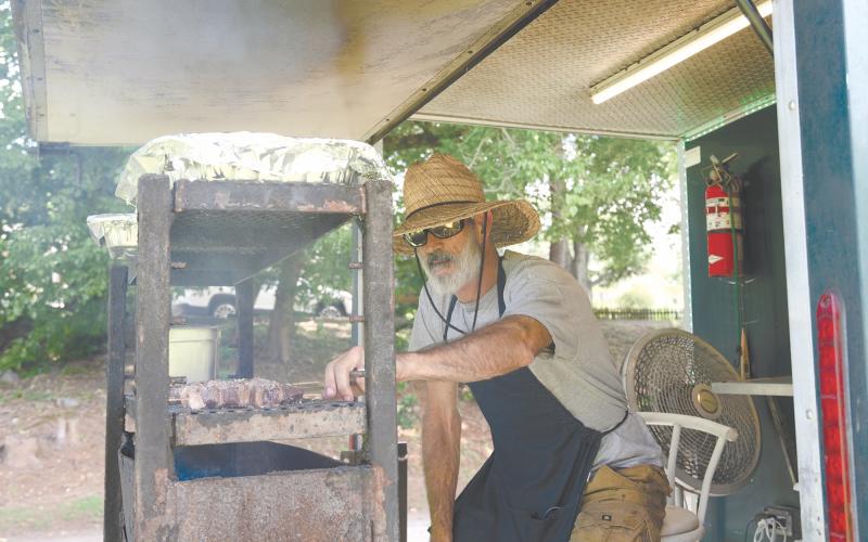 David Provine of Oba! Brazilian Barbecue rotates steak skewers on a charcoal grill for RiverFest patrons to enjoy. ZACH TAYLOR/Special