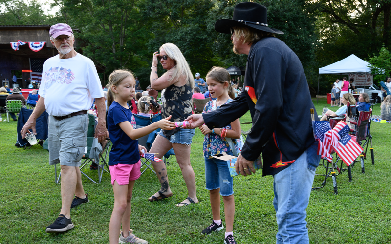 Steve Bryson gives out American Flags and bubbles to Gentry Huff and Adelyn Kimsey. ZACH TAYLOR/Special