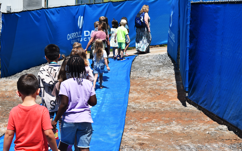 Mrs. Denise Rogers’ first grade class walks through the construction tunnel at  Clarkesville Elementary to reach their  playground at recess Wednesday.  The construction work goes on as the kids learn thanks to coordination between school leaders and workers to eliminate disruptions. MATTHEW OSBORNE/Staff