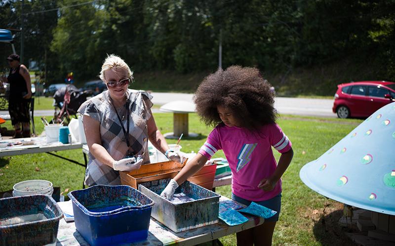 Dawn Gunn (left) helps Loralei hydro-dip her favorite colors onto pieces of cardstock at the Art-Full Barn’s 25th anniversary celebration Aug. 19. ZACH TAYLOR/Special
