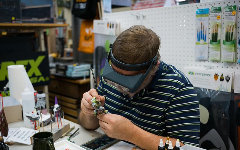 Greg Kimsey paints the details on an ork while talking to guests at the anniversary celebration. ZACH TAYLOR/Special