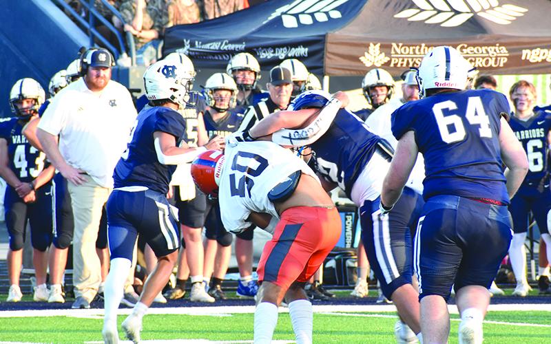 Habersham Central’s Alex Ethridge (50) gets “held” up on his way to White County quarterback Tripp Nix during last Friday’s game in Cleveland. Nix threw a touchdown on this play.  MATTHEW OSBORNE/Staff