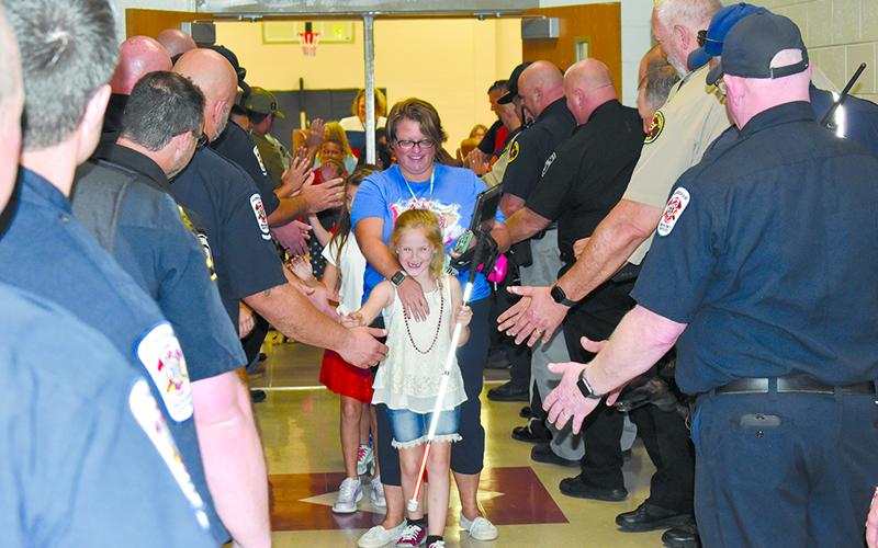 Phoebe Groves and Mrs. Sherry Crain come through the heroes’ parade tunnel. MATTHEW OSBORNE/Staff