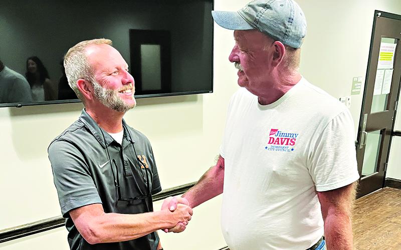 Demorest Councilmen Donnie Bennett and Jimmy L. Davis congratulate each other on wining their council races at the elections office Tuesday night. MATTHEW OSBORNE/Staff