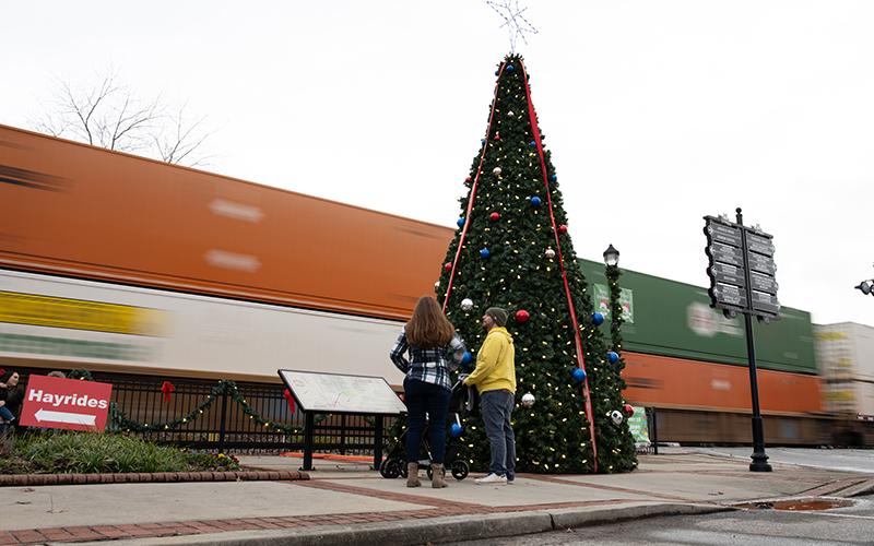 In typical Cornelia fashion, a train rolls by as Chris and Alicia Baratki stand next to the Christmas tree. ZACH TAYLOR/Special