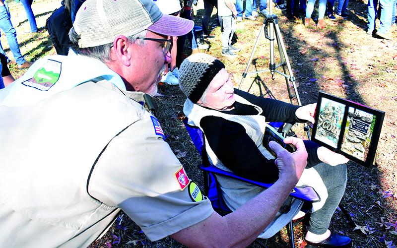 Scout Troop 5 Assistant Scoutmaster Alan Baker looks at a framed handbook page given to Alice Roseman that was left in the ground by her son Travis when he completed his Eagle Scout project in 1985. MATTHEW OSBORNE/Staff
