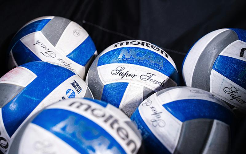 Volleyballs sit in a catch bin waiting to be used. UNSPLASH