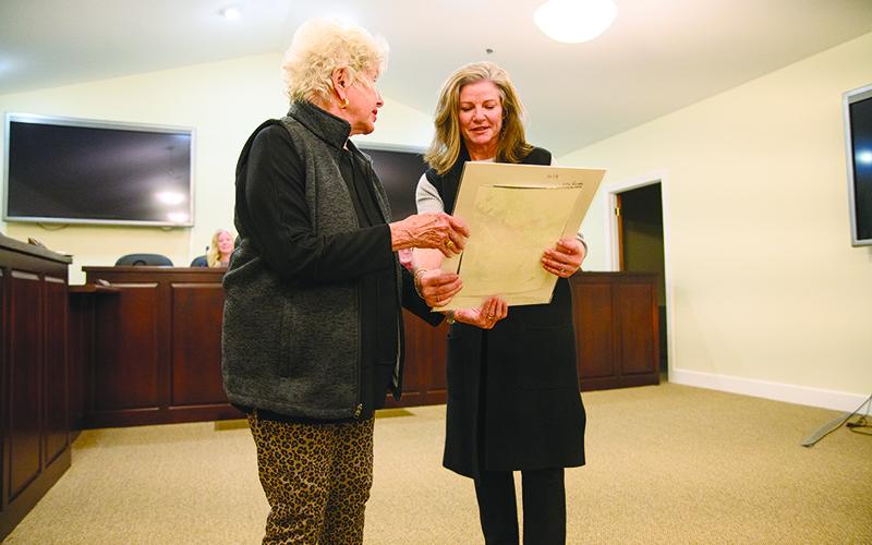 Clarkesville Mayor Barrie Aycock presents a piece of artwork to Leigh Johnston for her work involved with the Clarkesville Bicentennial year, including the mobile history trailer and the Founder’s Gala, which was hosted at Oak Heights in Clarkesville last month. ZACH TAYLOR/Special