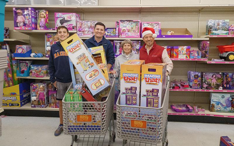 Carson Crane, Habersham Kiwanis Club President Brad Crane,  Habersham Kiwanis Club Secretary Nellie Snyder and Habersham Kiwanis Club Honorary Member Clay Christie stand behind full shopping carts for a photo. ZACH TAYLOR/Special