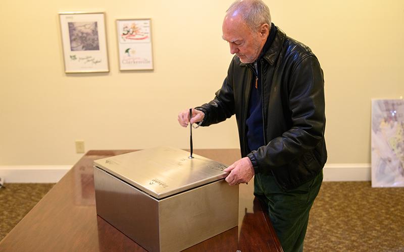 Councilmember Brad Coppedge uses a butter knife to open the time capsule. ZACH TAYLOR/Special