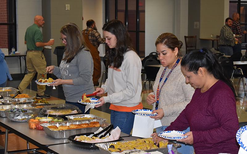 Teachers (from left) Shelby Day, Dallas Barron, Miriam Contreras and Elizabeth Addison take time to enjoy the delicious spread set for the faculty returning from the Christmas break. Students were set to return to school today. MATTHEW OSBORNE/Staff