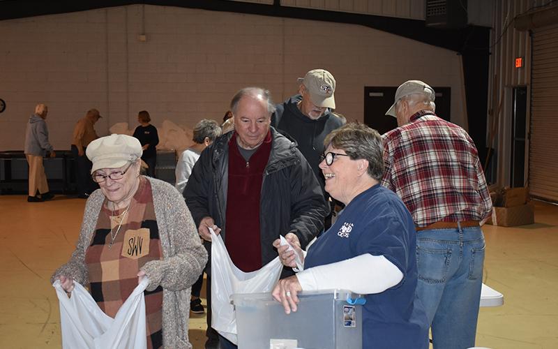 From left, Stella Ward, Bob Cook, Sam Watkins and Renè Grant work to fill the bags to be delivered to the schools later in the day. At far right is Richard Monroe. MATTHEW OSBORNE/Staff