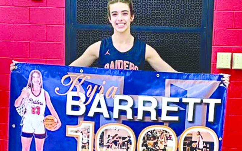 Kyia Barrett shows off her banner commemorating her 1,000th point. SUBMITTED