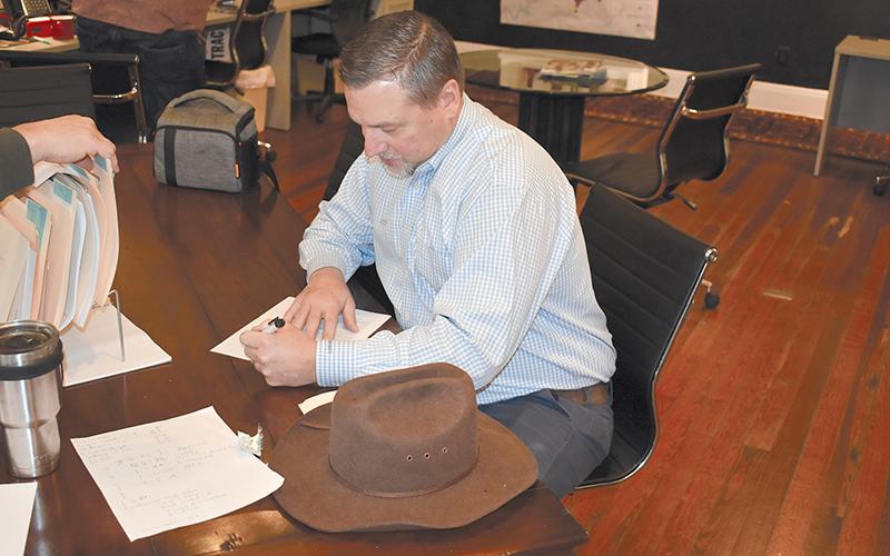 Ty Akins signs paperwork to run for a full term as District 5 Commissioner.
