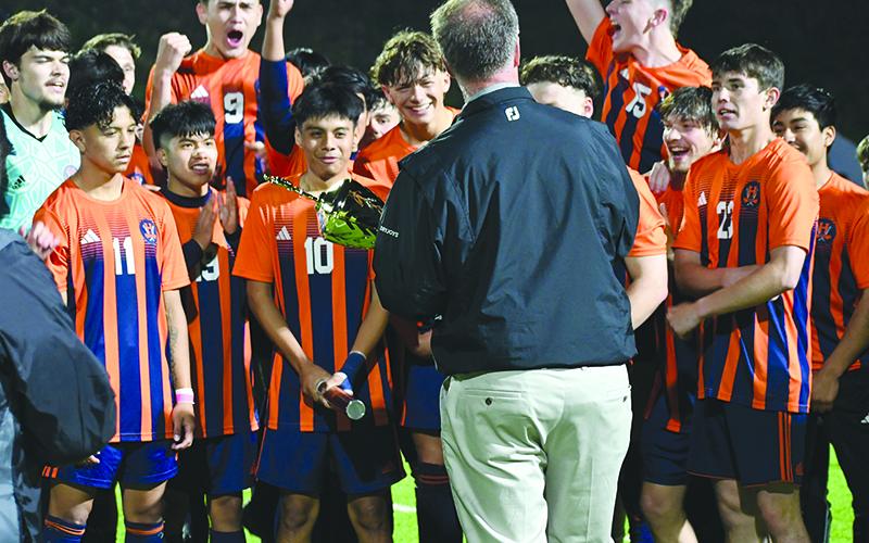 The Raiders anxiously await their trophy from Athletic Director Geep Cunningham after Tuesday’s win. LANG STOREY/Staff