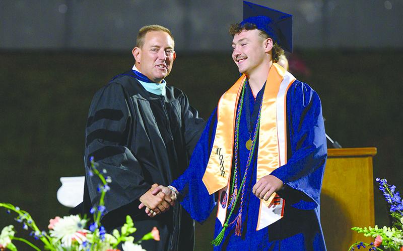Dr. Jonathan Stribling shares a laugh with graduate Brody Tyree on Friday night. Stribling took a job as White County’s assistant superintendent. ZACH TAYLOR/Special
