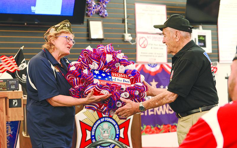 VFW Post 7720 Adjutant Connie Barrow gifts Andy Negra a wreath that reads “Home of the free because of the brave.” ZACH TAYLOR/Special