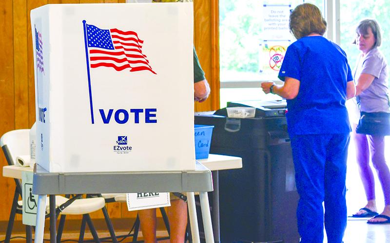 Poll workers cast ballots at Mud Creek Precinct during Tuesday’s election. Scan above for election results. JULIANNE AKERS/Staff