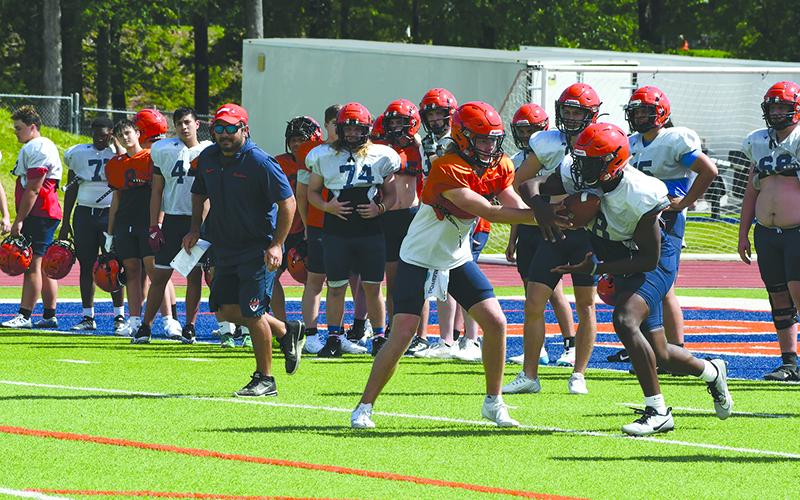 DJ Pass hands the ball off to Antonio Cantrell on Wednesday. LANG STOREY/Staff
