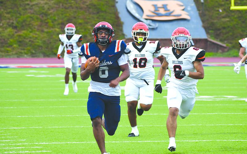 Raider running back Donovan Warren blazes past a pair of Hart County defenders on his way to a long touchdown run in Friday night’s spring game. LANG STOREY/Staff