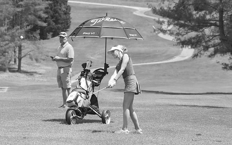 Maddie LaPrade hits a chip on hole No. 17 Monday as HCHS coach Shawn Blackburn looks on. LANG STOREY/Staff