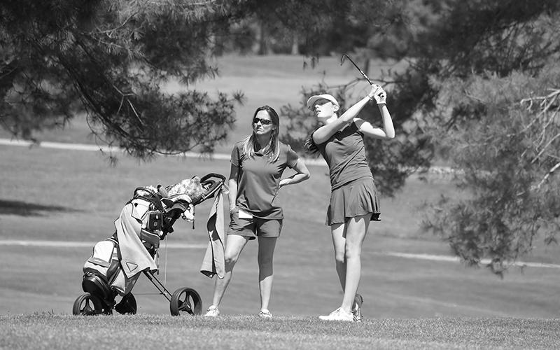 HCHS assistant coach Joni Blackburn looks on as Charlotte Smith hits her approach shot. LANG STOREY/Staff