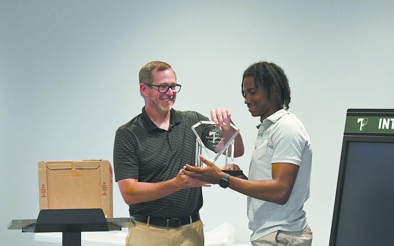 TFS coach Justin Pollock presents Indians’ catcher Caden Walker with the team’s MVP award at the banquet Tuesday. LANG STOREY/Staff