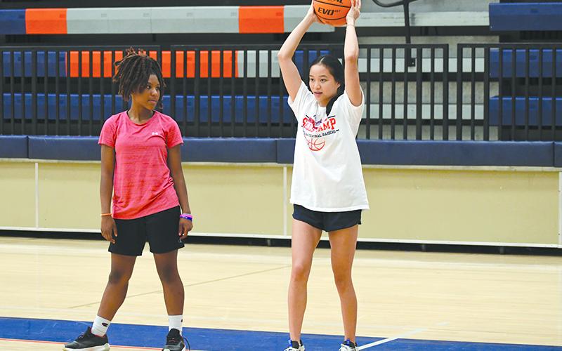 Camper Harmony Warren looks on as former Lady Raider Jazky Bantaum demonstrates an overhead pass. LANG STOREY/Staff