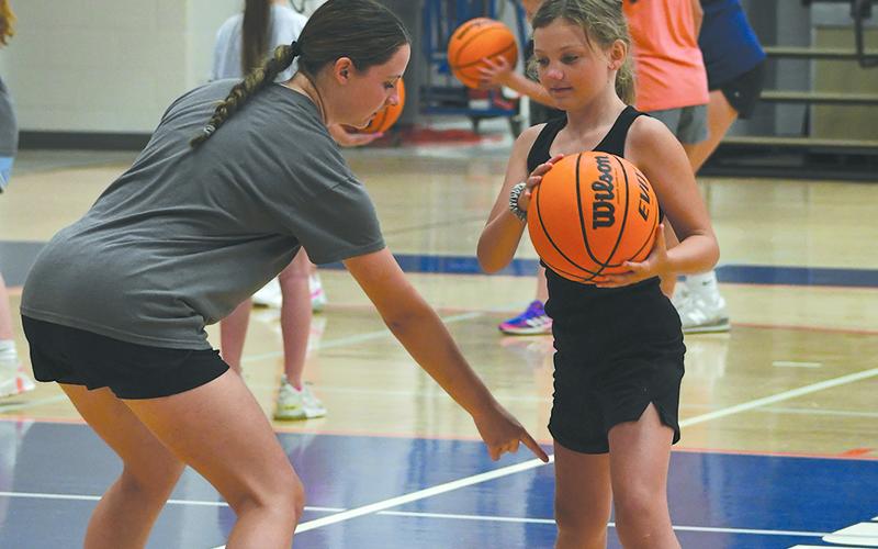 HCHS’ Oaklee Jackson instructs camper Ryelin London at camp on Monday. LANG STOREY/Staff